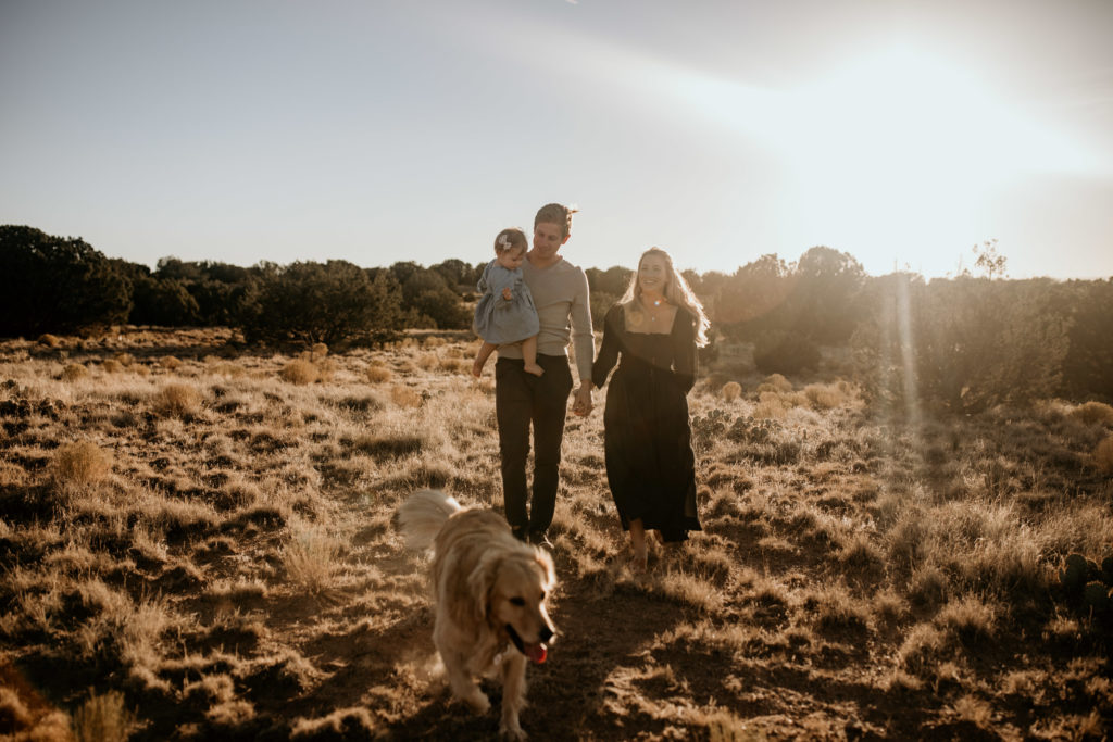 family and dog walking through the desert