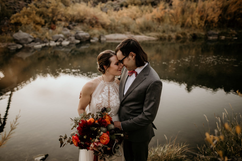 bride and groom by the rio grande river in Taos New Mexico