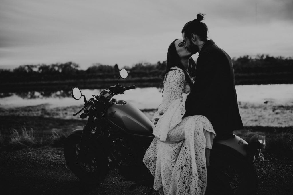 bride and groom sitting on a motorcycle kissing