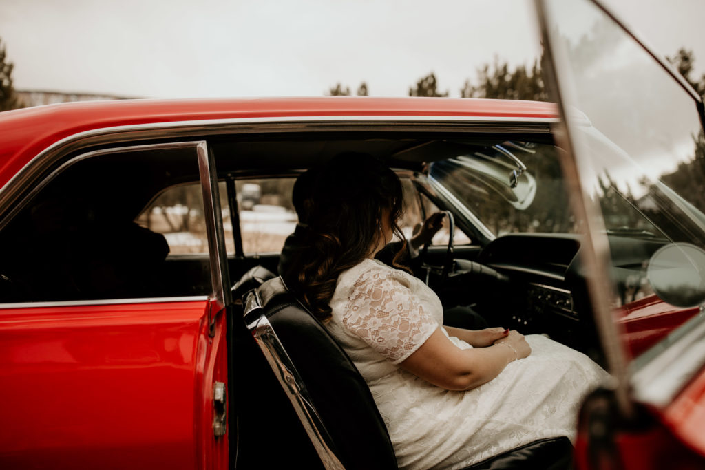 husband and wife sitting in a 63 Cadillac after their elopement