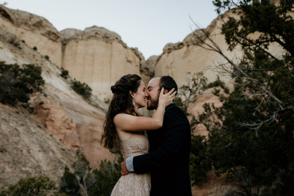 bride and groom kissing in front of a canyon in Abiquiu, NM