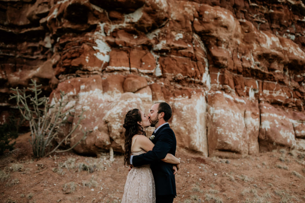 newlyweds kidding in front of red rocks in New Mexico