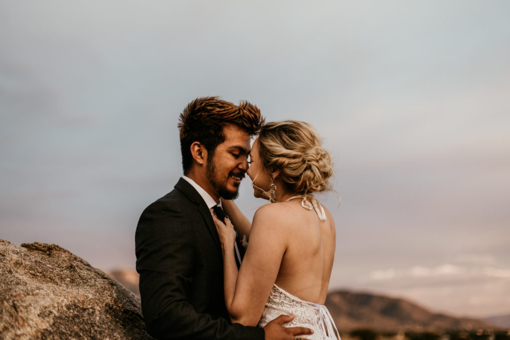 bride and groom about to kiss in front of the Sandia Mountains in Albuquerque