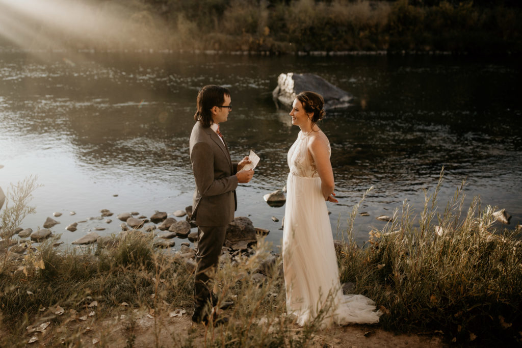 bride and groom saying vows next to the rio grande river in Taos