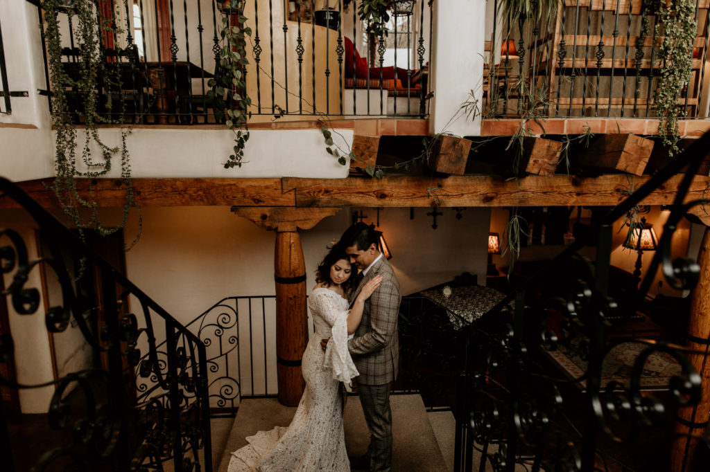 newlyweds holding on each other on a southwest style staircase