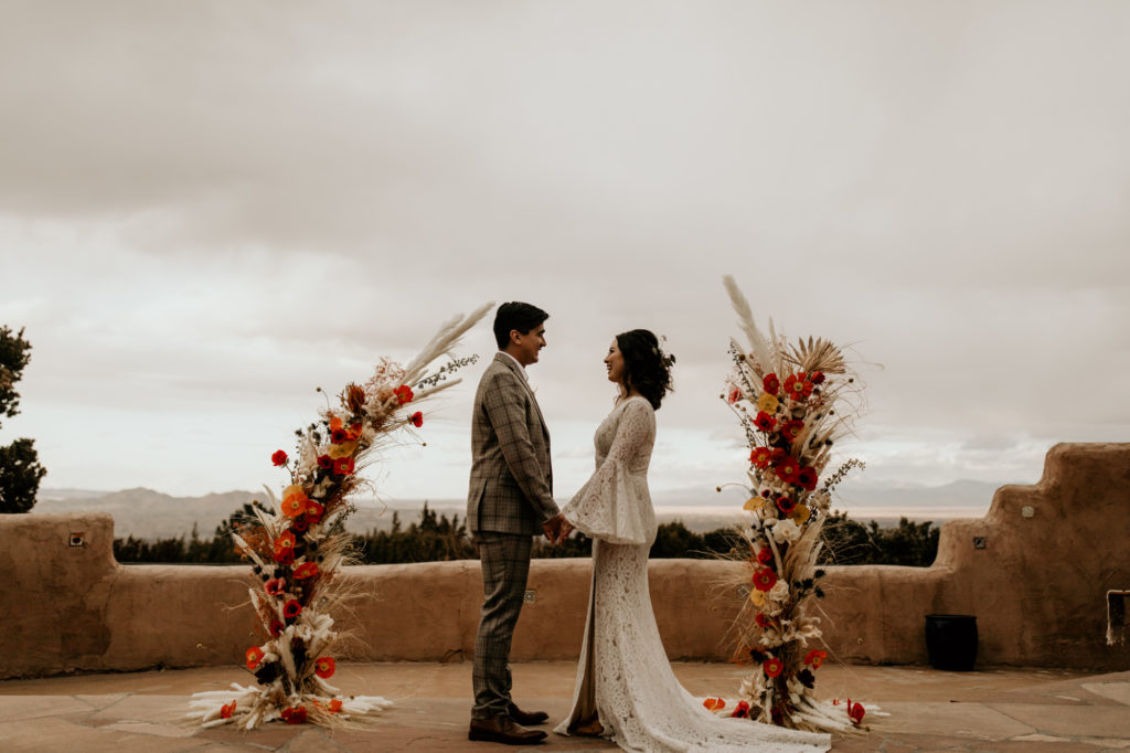 bride and groom saying vows in a courtyars of an adobe building in Santa Fe