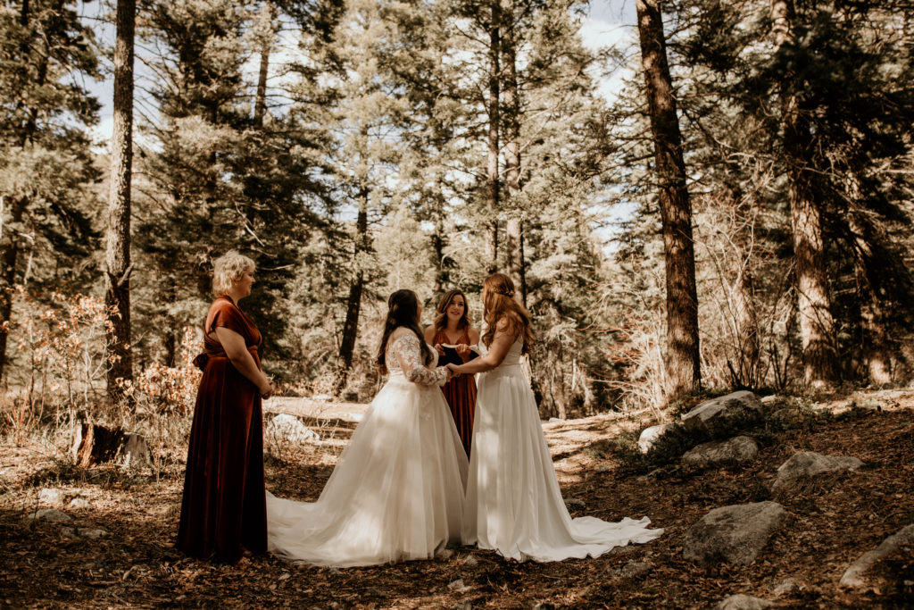 two woman saying their vows in a forest in Taos New Mexico