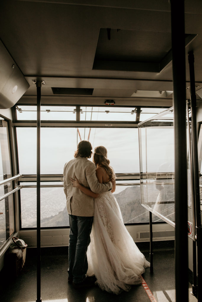 newlyweds rideing the sandia peak tram in their wedding attire