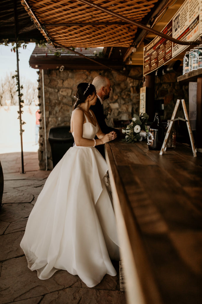 bride and groom standing at a bar ordering drinks at a santa fe brewery