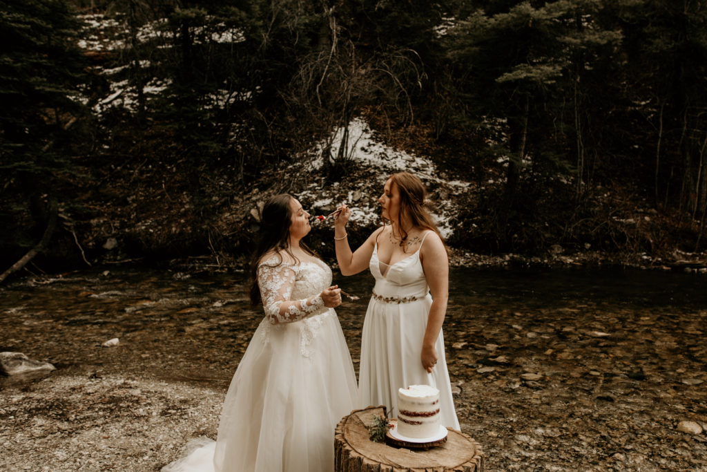 two brides feeding each other cake