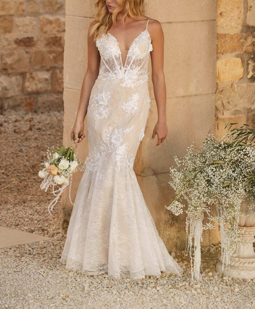 woman wearing a lace wedding dress holing flowers