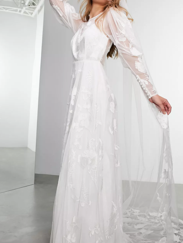 model wearing an embroidered long sleeve wedding gown